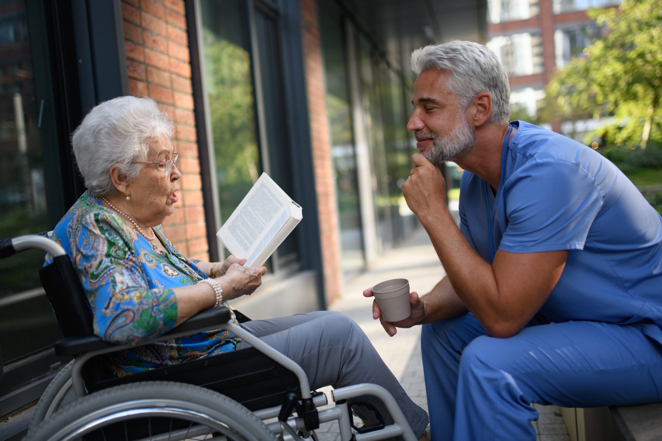 The woman is holding a large black binder open and gesturing toward the contents while the man looks on intently.